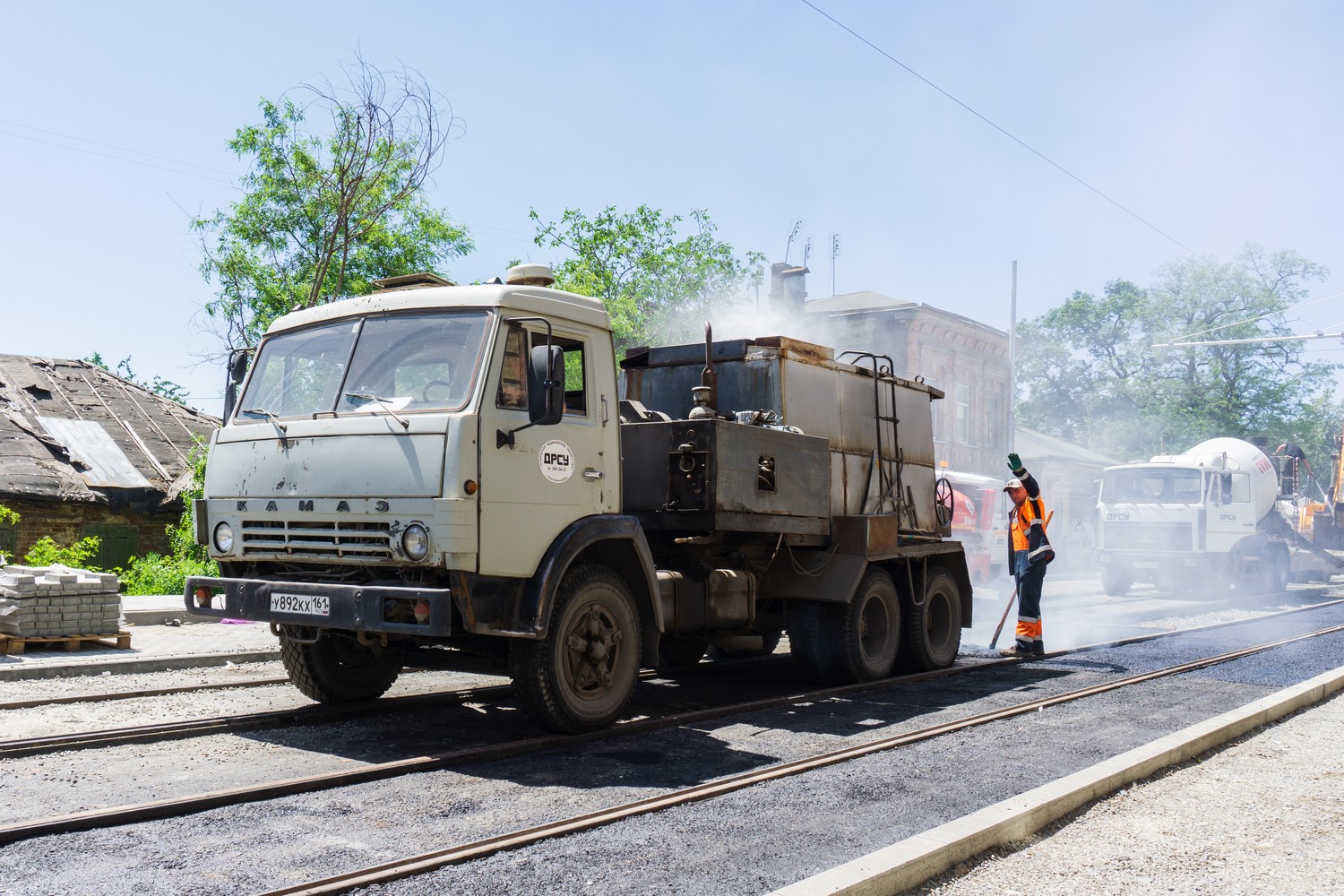 Paving crew placing fresh hot-mix asphalt on a commercial lot